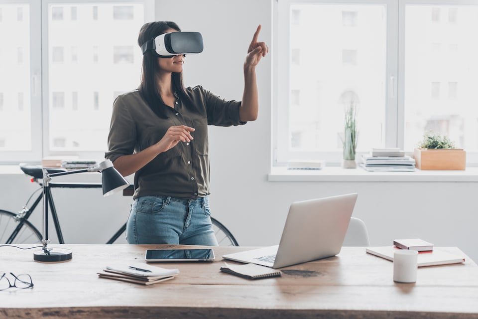 KNTXT Group - woman using virtual reality headset in an office